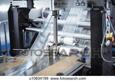 Printed material passing through food packaging printer in print factory View Large Photo Image Stock Photo - Printed material passing through food packaging printer in print factory. Fotosearch