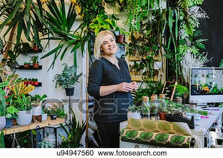 Proud owner smiling in plant nursery View Large Photo Image Stock Image - Proud owner smiling in plant nursery. Fotosearch