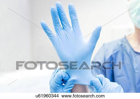 Picture - Putting glove on surgeon. Fotosearch