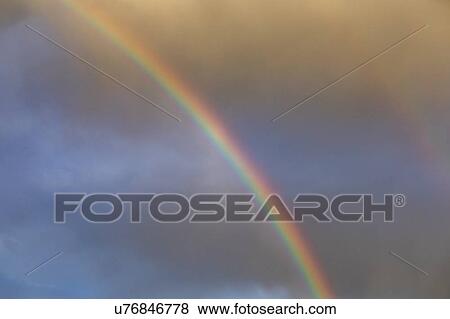Rainbow against overcast sky View Large Photo Image Stock Photo - Rainbow against overcast sky. Fotosearch