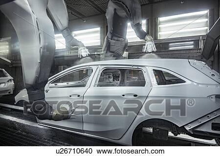 Stock Image - Robot paint spraying car bodies in car factory. Fotosearch