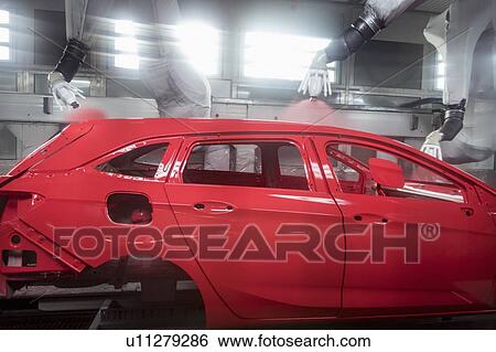 Stock Photograph - Robot paint spraying car bodies in car factory. Fotosearch