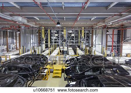Stock Image - Robotic car body storage in car factory. Fotosearch
