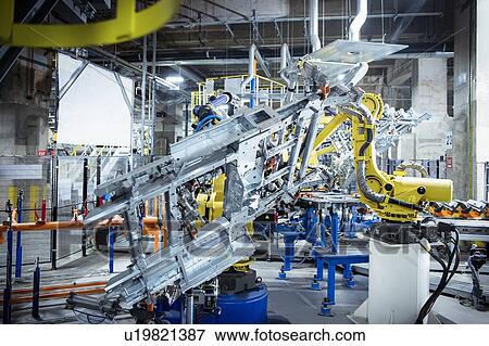 Stock Photo - Robots spot welding car parts in car factory. Fotosearch