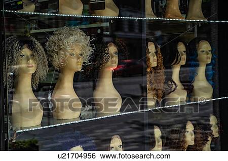 Stock Photograph - Row of mannequin heads displaying variety of wigs in shop window. Fotosearch
