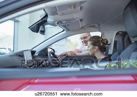 Salesman demonstrating car controls to customer in car dealership View Large Photo Image Stock Image - Salesman demonstrating car controls to customer in car dealership. Fotosearch