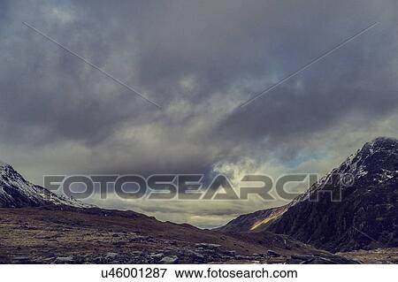 Stock Photo - Scenic snow capped mountain landscape and storm clouds, Llanberis, Gwynedd, Wales. Fotosearch