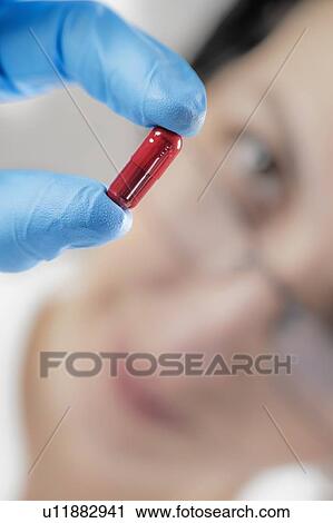 Scientist holding red pill View Large Photo Image Stock Image - Scientist holding red pill. Fotosearch