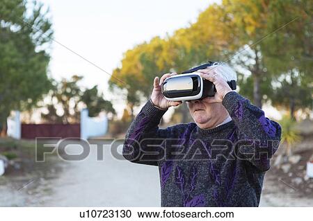Senior man wearing virtual reality simulator outdoors View Large Photo Image Stock Image - Senior man wearing virtual reality simulator outdoors. Fotosearch