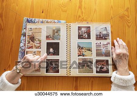 Stock Photography - Senior woman looking at old photos. Fotosearch