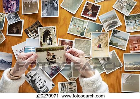 Stock Image - Senior woman looking at photo album. Fotosearch