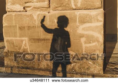 Shadow of woman taking selfie on stone wall View Large Photo Image Stock Image - Shadow of woman taking selfie on stone wall. Fotosearch