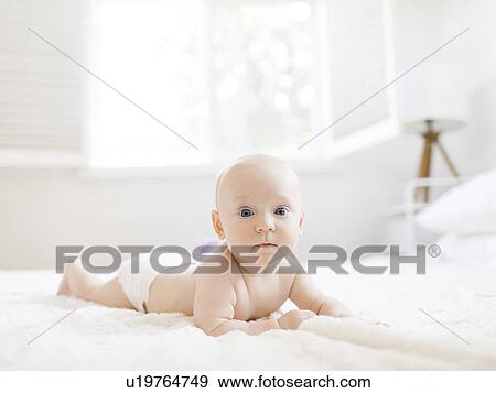 Shirtless baby boy lying on bed View Large Photo Image Stock Photo - Shirtless baby boy lying on bed. Fotosearch