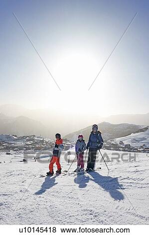 Stock Photo - Skiers, mother with daughter and teenage son on snow covered mountain top, portrait, Alpe-d'Huez, Rhone-Alpes, France. Fotosearch