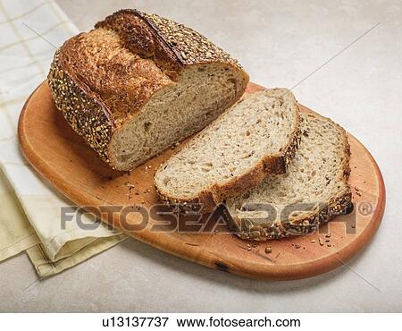 Sliced loaf of bread on cutting board View Large Photo Image Stock Photo - Sliced loaf of bread on cutting board. Fotosearch