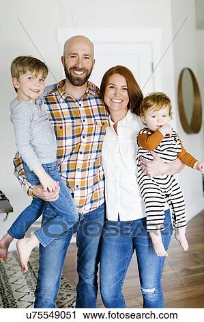 Stock Image - Smiling family in home. Fotosearch