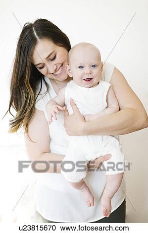 Smiling woman carrying her baby boy View Large Photo Image Stock Image - Smiling woman carrying her baby boy. Fotosearch