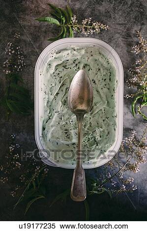 Stock Photography - Spoon on mint chocolate ice cream with flowers. Fotosearch
