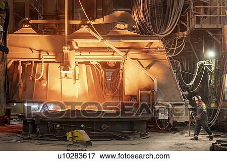 Stock Photo - Steel worker taking sample from furnace in steelworks. Fotosearch
