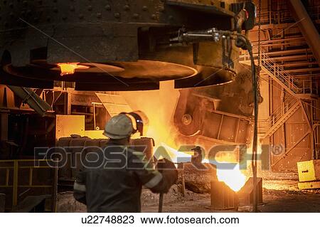 Steelworker looking on as molten steel flask is emptied during steel pour in steelworks View Large Photo Image Stock Image - Steelworker looking on as molten steel flask is emptied during steel pour in steelworks. Fotosearch