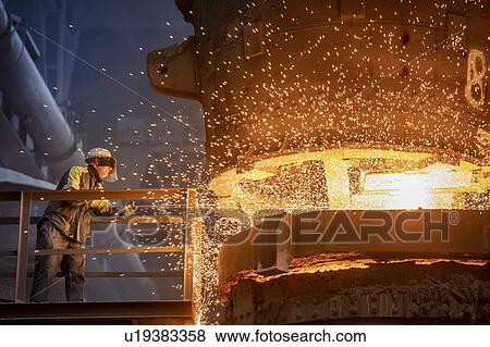 Stock Photo - Steelworker starting molten steel pour in steelworks. Fotosearch