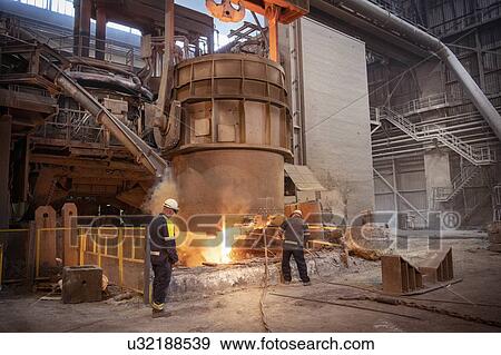 Stock Photo - Steelworkers testing pour of molten steel from ladle in steelworks. Fotosearch