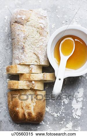 Still life of floured and unfloured ciabatta loaf on baking tray with bowl and spoon, overhead view View Large Photo Image Stock Photography - Still life of floured and unfloured ciabatta loaf on baking tray with bowl and spoon, overhead view. Fotosearch