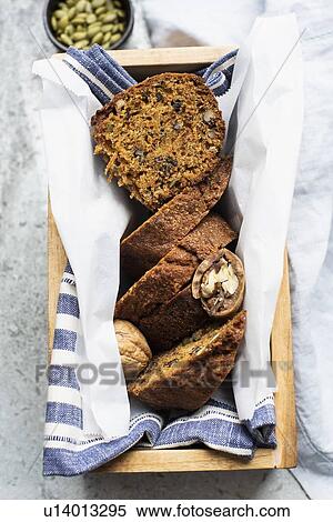 Still life of walnut and pumpkin seed cake sliced and wrapped in tea towel in wooden box, overhead view View Large Photo Image Stock Photography - Still life of walnut and pumpkin seed cake sliced and wrapped in tea towel in wooden box, overhead view. Fotosearch