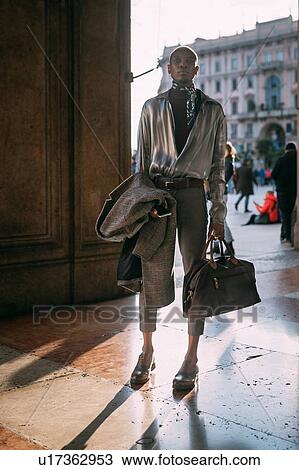 Stock Image - Stylish man by period buildings by piazza, Milan, Italy. Fotosearch