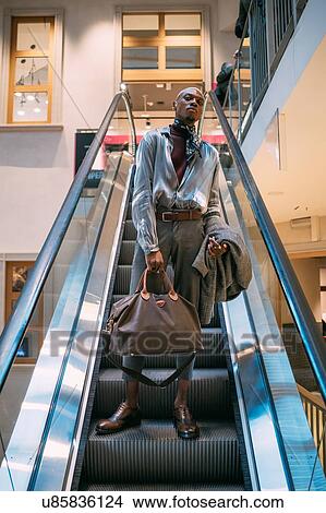 Stylish man descending on escalator, Milan, Italy View Large Photo Image Picture - Stylish man descending on escalator, Milan, Italy. Fotosearch