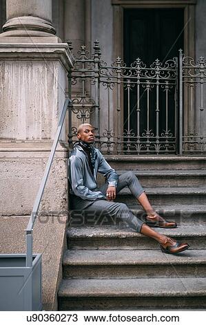 Stylish man sitting on steps of period building, Milan, Italy View Large Photo Image Stock Image - Stylish man sitting on steps of period building, Milan, Italy. Fotosearch