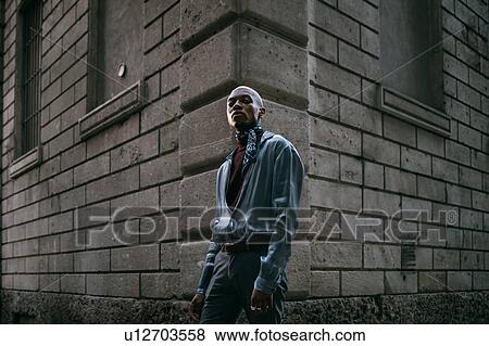 Stock Photo - Stylish man standing at corner of period building, Milan, Italy. Fotosearch