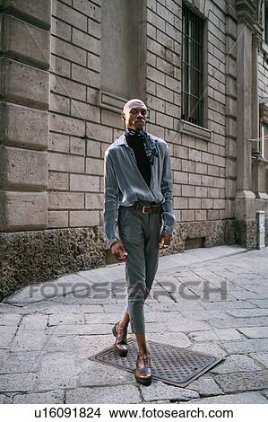 Picture - Stylish man standing by period building, Milan, Italy. Fotosearch