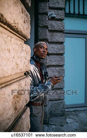 Stylish man using cellphone by period building, Milan, Italy View Large Photo Image Stock Image - Stylish man using cellphone by period building, Milan, Italy. Fotosearch