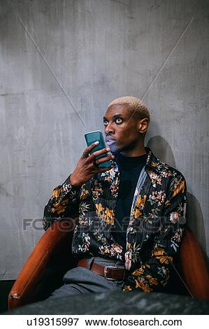 Stylish man using cellphone, concrete wall background View Large Photo Image Stock Photo - Stylish man using cellphone, concrete wall background. Fotosearch
