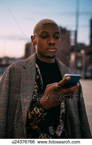 Stock Photograph - Stylish man using cellphone, Milan, Italy. Fotosearch