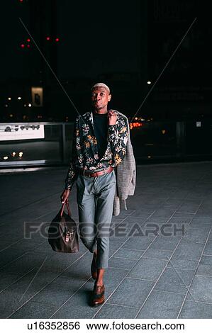 Stylish man walking in street at night, Milan, Italy View Large Photo Image Stock Photograph - Stylish man walking in street at night, Milan, Italy. Fotosearch