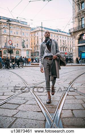 Stylish man walking over tram tracks in piazza, Milan, Italy View Large Photo Image Stock Image - Stylish man walking over tram tracks in piazza, Milan, Italy. Fotosearch