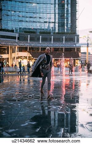 Stylish man walking through piazza, water feature in background, Milan, Italy View Large Photo Image Stock Image - Stylish man walking through piazza, water feature in background, Milan, Italy. Fotosearch