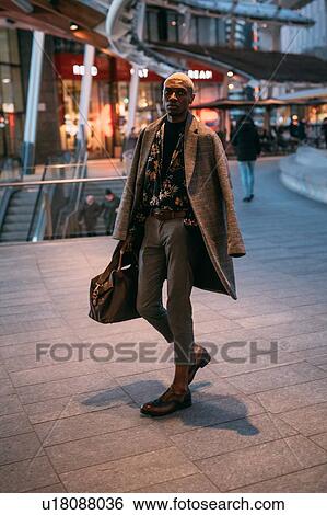 Stock Photograph - Stylish man walking through piazza, Milan, Italy. Fotosearch