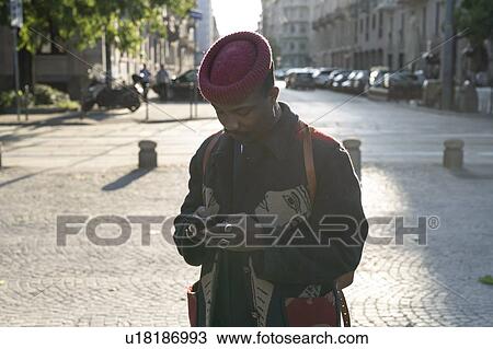 Stylish man with hat using cellphone on street, Milan, Italy View Large Photo Image Stock Image - Stylish man with hat using cellphone on street, Milan, Italy. Fotosearch