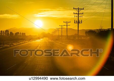 Stock Image - Sunset over country road in Picabo, Idaho, USA. Fotosearch
