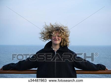 Teenage girl leaning against handrail on windy day View Large Photo Image Stock Image - Teenage girl leaning against handrail on windy day. Fotosearch