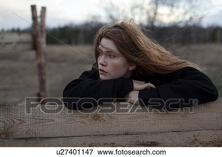 Teenage girl leaning on wooden fence View Large Photo Image Stock Photo - Teenage girl leaning on wooden fence. Fotosearch