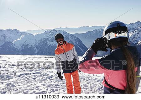 Teenage girl skier taking photo of teenage brother on snow covered mountain top, Alpe-d'Huez, Rhone-Alpes, France View Large Photo Image Stock Photo - Teenage girl skier taking photo of teenage brother on snow covered mountain top, Alpe-d'Huez, Rhone-Alpes, France. Fotosearch