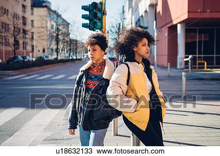 Two cool young women standing on city street View Large Photo Image Stock Image - Two cool young women standing on city street. Fotosearch