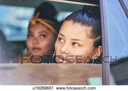 Two teenage girls in car back seat looking out of car window, close up View Large Photo Image Stock Image - Two teenage girls in car back seat looking out of car window, close up. Fotosearch