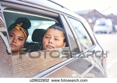 Two teenage girls in car back seat looking out of car window View Large Photo Image Stock Image - Two teenage girls in car back seat looking out of car window. Fotosearch