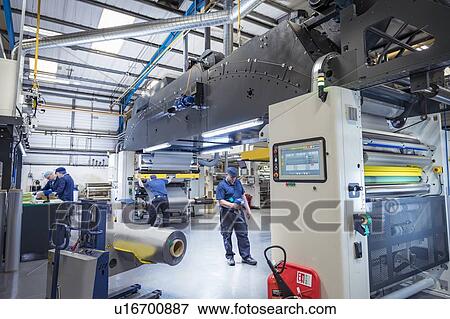 Wide angle view of food packaging machine and workers in print factory View Large Photo Image Stock Photo - Wide angle view of food packaging machine and workers in print factory. Fotosearch