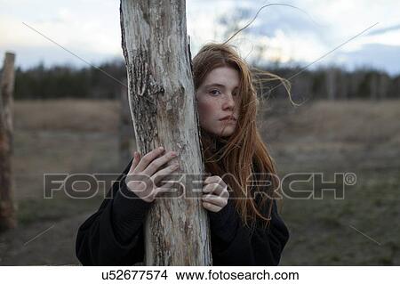 Windswept teenage girl by tree trunk View Large Photo Image Picture - Windswept teenage girl by tree trunk. Fotosearch